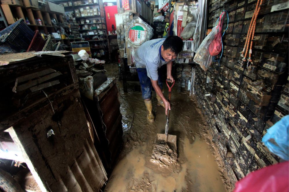 A motorcycle mechanic cleans his mud-filled workshop after floodwaters recede in Maran, Pahang January 10, 2021. u00e2u20acu201d Reuters pic