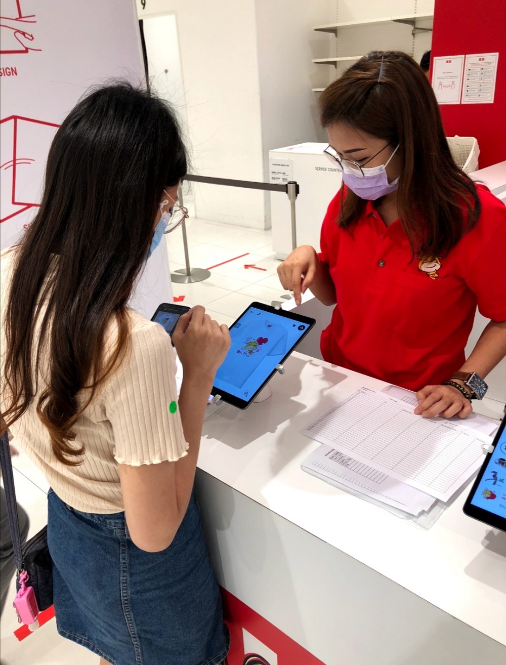 A customer selects Moo Moo Da stickers for her customised Uniqlo T-shirt. ― Picture courtesy of Astro