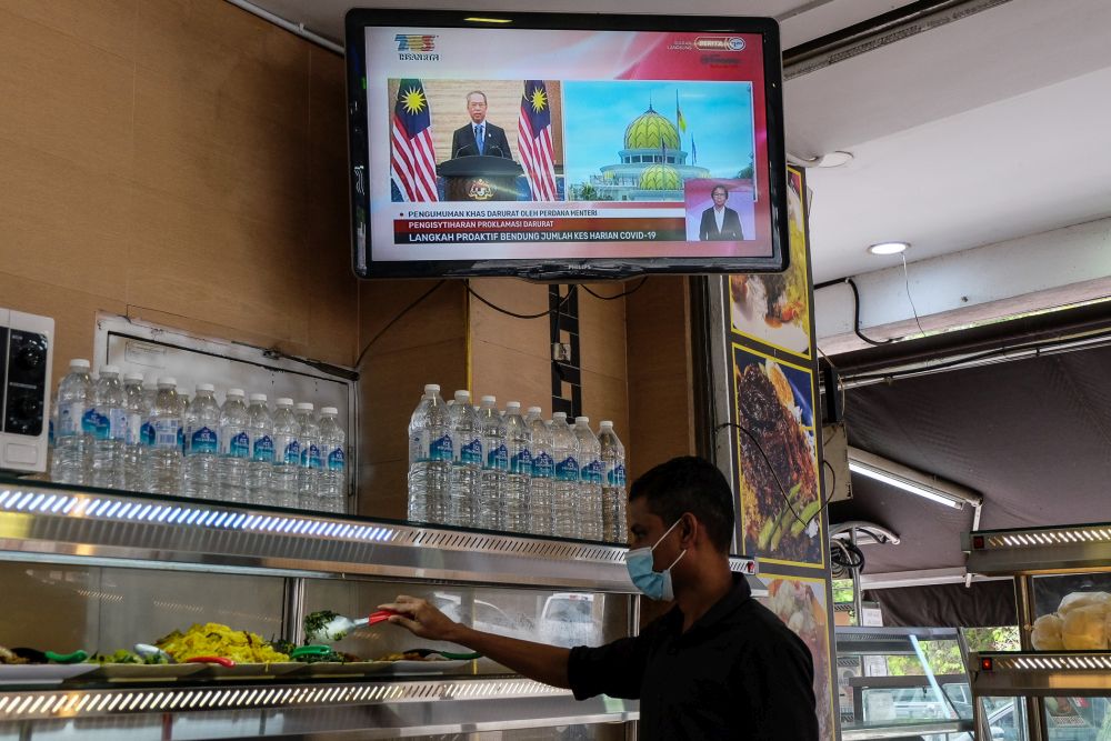 A live telecast of Prime Minister Tan Sri Muhyiddin Yassin's speech on the Emergency proclamation is seen at a restaurant in Shah Alam January 12, 2020. u00e2u20acu201d Picture by Yusof Mat Isa