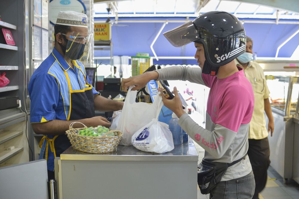 A food delivery rider picks up his order at Hakim Nasi Kandar, Shah Alam January 13, 2021. u00e2u20acu201d Picture by Miera Zulyanann