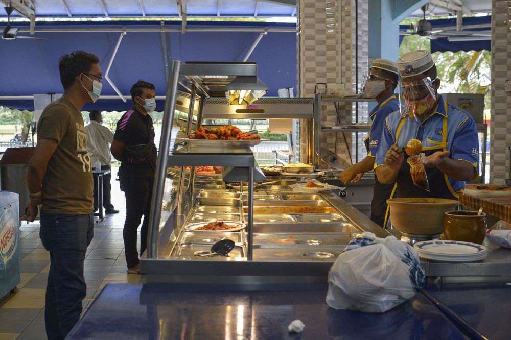 Customers queue for takeaway at Hakim Nasi Kandar, Shah Alam January 13, 2021. u00e2u20acu201d Picture by Miera Zulyana