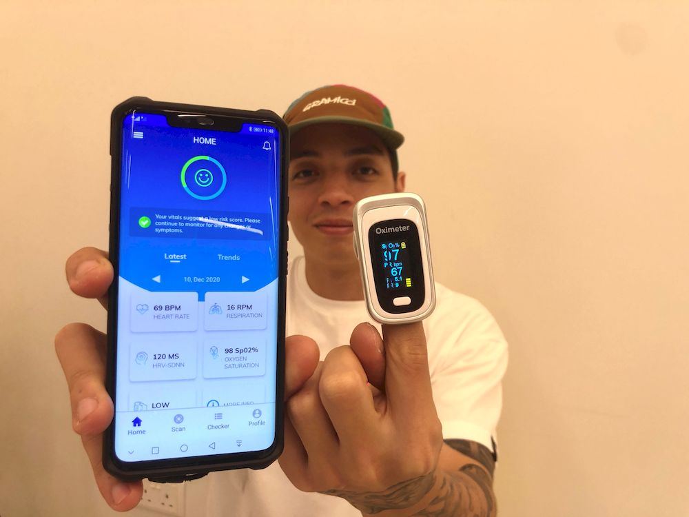 A Mighty Jaxx employee comparing his vital sign reading taken by the application with a reading from a fingertip pulse oximeter. — TODAY pic