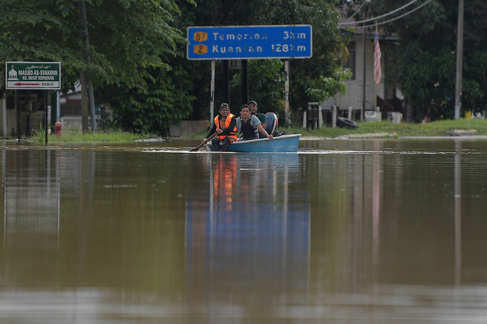 Residents on a boat brave the floods on the main road area connecting the city of Temerloh-Mentakab in Pahang, January 8, 2021. u00e2u20acu201d Bernama pic 