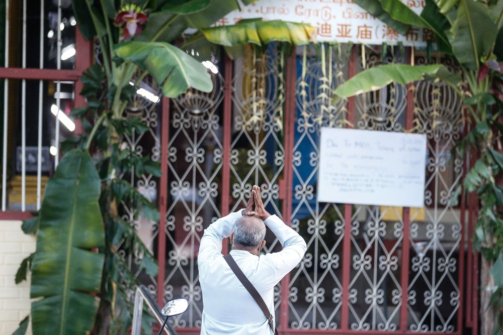 A Hindu devotee prays outside the Nattukotai Chettiar Temple in George Town during Thaipusam January 28, 2021. — Picture by Farhan Najib