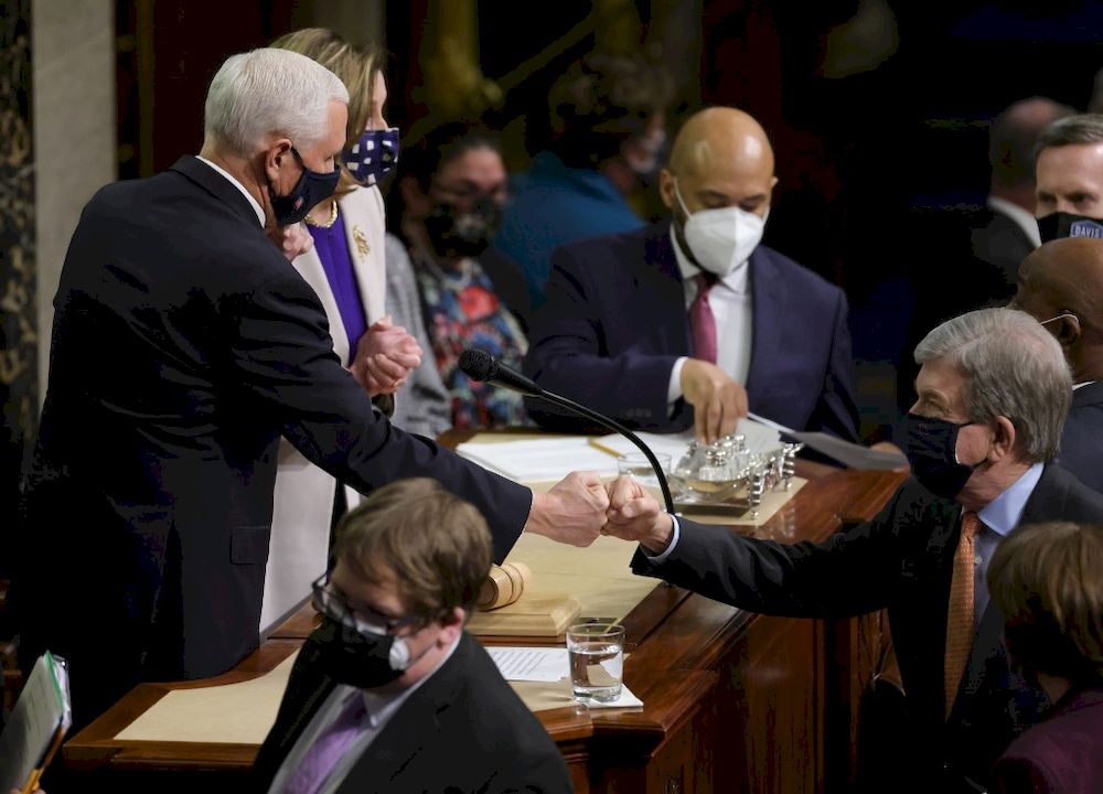 Vice President Mike Pence (left) bumps fists with US Sen. Roy Blunt (right) (R-MO) at the conclusion of the count of electoral votes in the House Chamber during a reconvening of a joint session of Congress on January 07, 2021 in Washington, DC. u00e2u20acu201d Getty 
