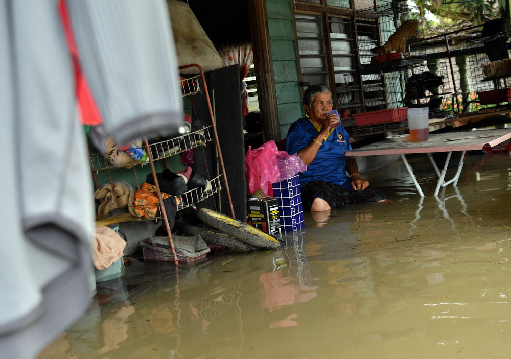 Mahani Zakaria, 69, enjoys a drink after removing items from his house which was affected by the flood during a Bernama survey in Kampung Changkat Jong, Teluk Intan, Perak, January 4, 2021. u00e2u20acu201d Bernama pic 