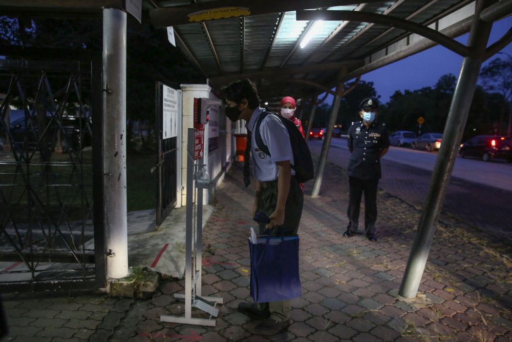 A student has his temperature recorded at Sekolah Menengah Kebangsaan Bukit Jelutong in Shah Alam January 20, 2021. u00e2u20acu201d Picture by Yusof Mat Isa