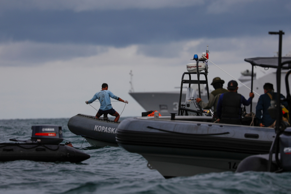 An Indonesian navy diver stand on a rubber boat holds a rope during the search and rescue operation for the Sriwijaya Air flight SJ 182, at the sea off the Jakarta coast, Indonesia, January 12, 2021. u00e2u20acu201d Reuters picnn