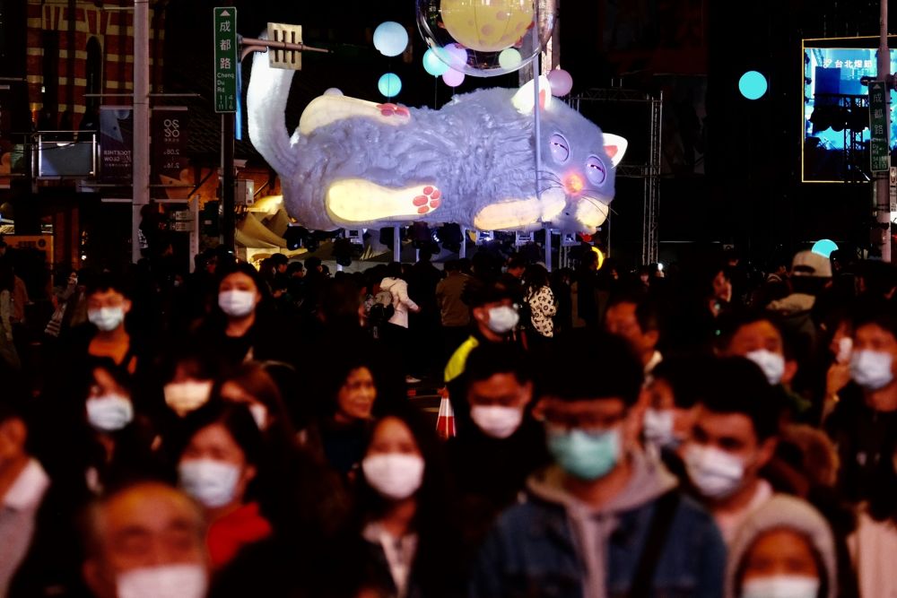 People wearing protective face masks walk past a cat-shaped lantern during the lunar lanterns festival following the Lunar New Year in Taipei on February 8, 2020. u00e2u20acu201d AFP pic