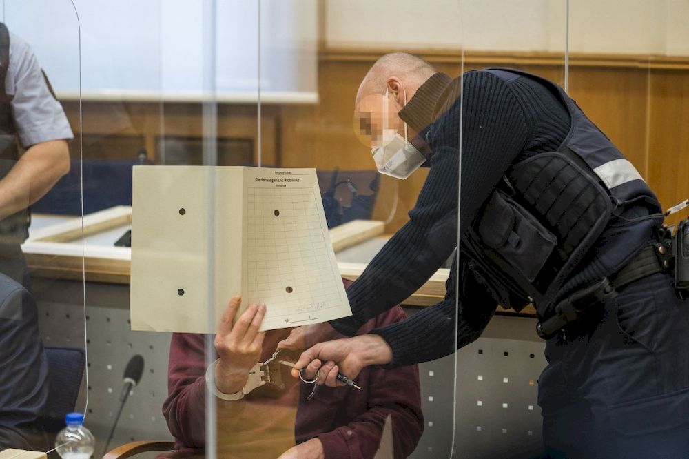 A justice official removes the handcuffs of Syrian defendant Eyad al-Gharib, accused of crimes against humanity, as he waits to hear the verdict in the court room, February 24, 2021 in Koblenz, Germany. u00e2u20acu201d AFP pic