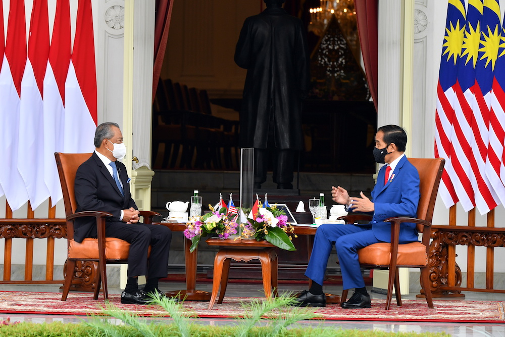Indonesian President Joko Widodo talks with Malaysian Prime Minister Tan Sri Muhyiddin Yassin during a meeting at the Presidential Palace in Jakarta, Indonesia, February 5, 2021. u00e2u20acu201d Agus Suparto/Indonesia's Presidential Palace handout via Reuters