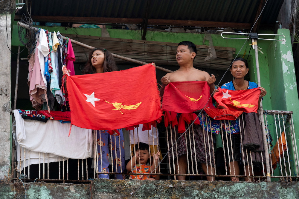 People hold National League for Democracy (NLD) party flags on their balcony as they take part in a protest against the military coup and to demand the release of elected leader Aung San Suu Kyi, in Yangon, Myanmar February 7, 2021. — Reuters pic