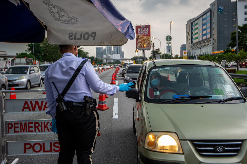 Police officers conducting checks at a roadblock in Sungai Besi, Kuala Lumpur February 16, 2021. u00e2u20acu201d Picture by Shafwan Zaidon