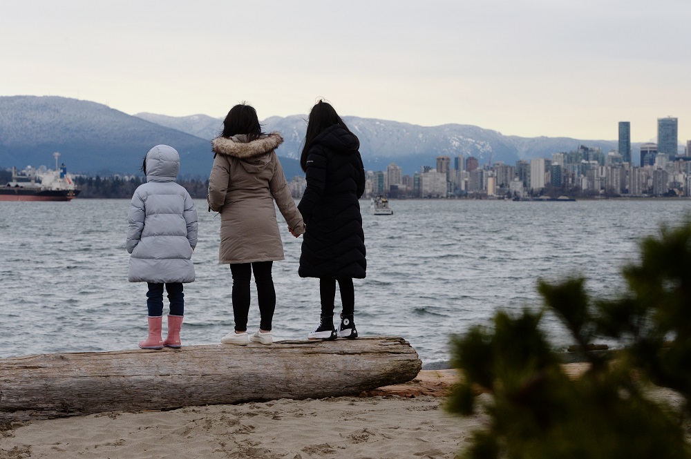 Maria Law, who emigrated from Hong Kong with her family, views the skyline with her daughters from Jericho Beach in Vancouver, British Columbia, Canada January 26, 2021. u00e2u20acu201d Reuters pic