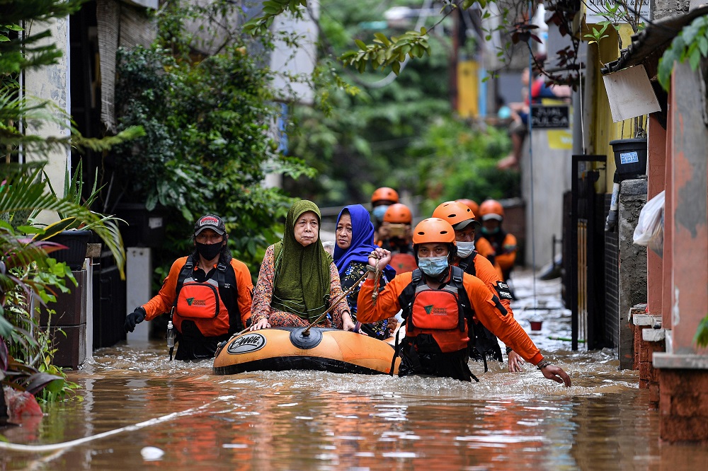 Volunteers evacuate elderly women with an inflatable boat in an area affected by floods, following heavy rains in Jakarta February 19, 2021. u00e2u20acu201d Picture by Antara Foto via Reuters
