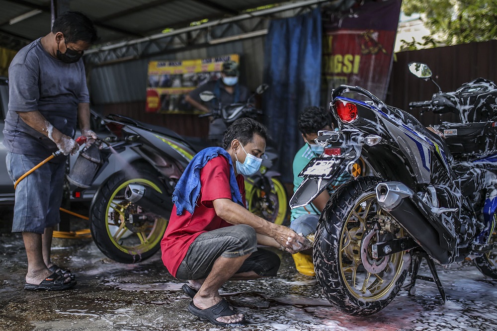 Staff at a car wash centre are seen hard at work in Kuala Lumpur February 6, 2021. u00e2u20acu201d Picture by Hari Anggara
