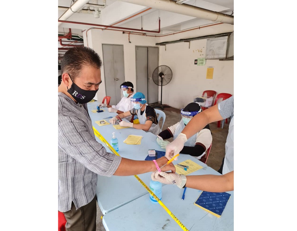 Covid-19 case 33 celebrating the cutting of his pink wrist tag. — Picture by Rosli Dahlan