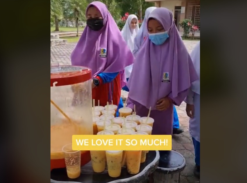 Students help themselves to ‘air jagung’ prepared by Hanif.  —  Screengrab from TikTok/sir_asai