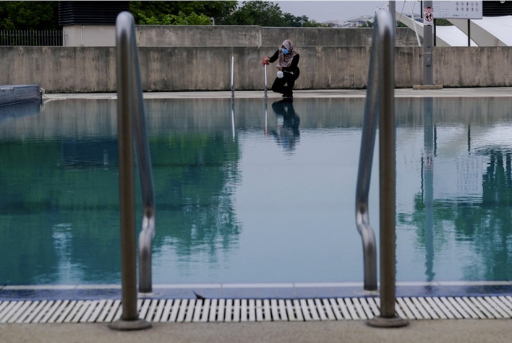 A worker sanitises the area surrounding a public pool in Putrajaya, June 27, 2020. u00e2u20acu201d Bernama pic