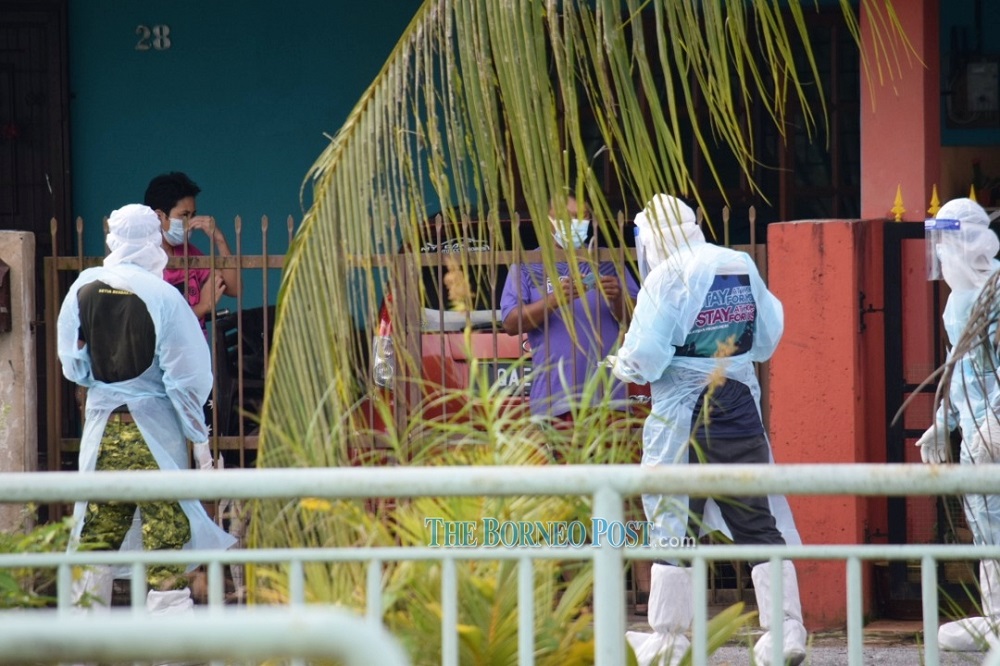Residents at Univista undergo interviews and health tests as medical personnel can be seen going house to house. — Picture by Roystein Emmor via Borneo Post Online
