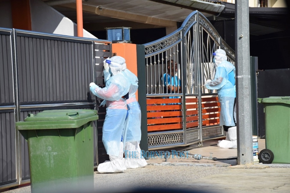 Medical personnel interviewing residents during house-to-house screening at Univista today. u00e2u20acu201d Picture by Roystein Emmor via Borneo Post Online