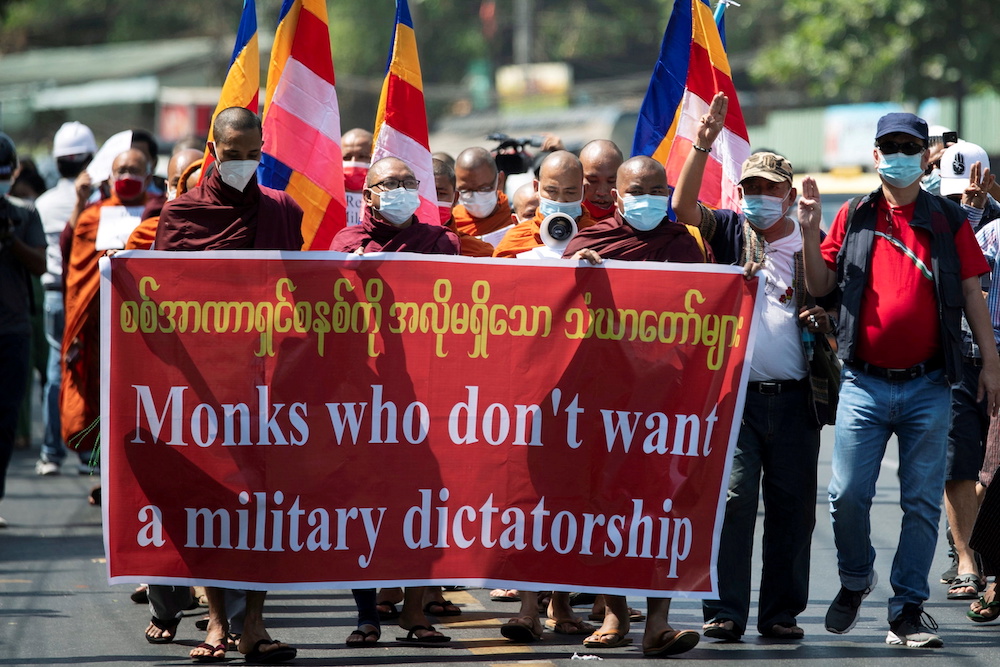 Saffron monks holding a banner walk during a protest against the military coup in Yangon, Myanmar February 16, 2021. u00e2u20acu201d Reuters/Stringer pic