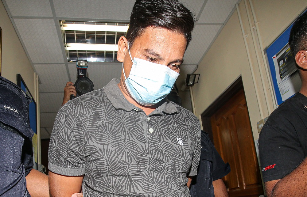 Ruddy Nezeri Kamarudin is led in handcuffs out of the Session Court in Ipoh February 18, 2021. u00e2u20acu201d Picture by Farhan Najib