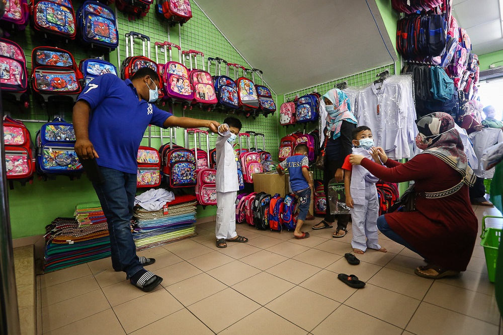 Parents shop for new school uniforms for their child at Pusat Pakaian Hari-Hari in Shah Alam February 20, 2021. u00e2u20acu201d Picture by Yusof Mat Isa