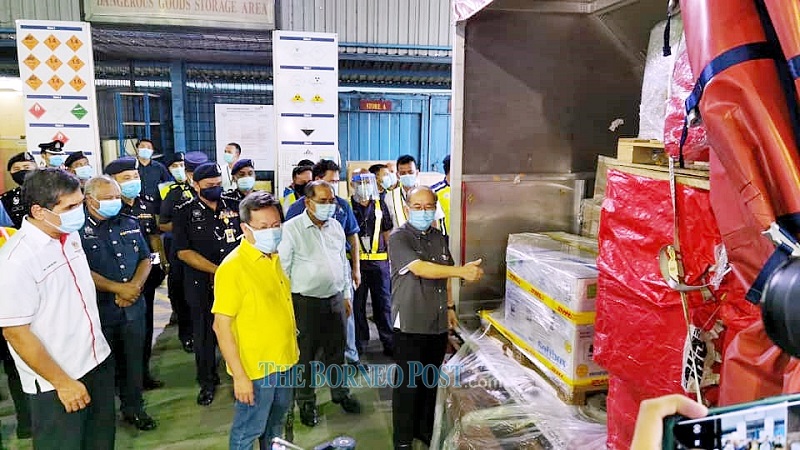 Dr Sim (second left) and Uggah (right) overseeing the arrival of the vaccines at the airport’s cargo hangar. — Picture by Chimon Upon via Borneo Post Online