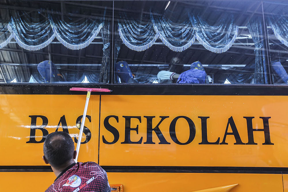 Car wash workers are seen cleaning school buses in preparation for schools reopening on Monday, Petaling Jaya February 27, 2020. u00e2u20acu2022 Picture by Hari Anggara.nnn