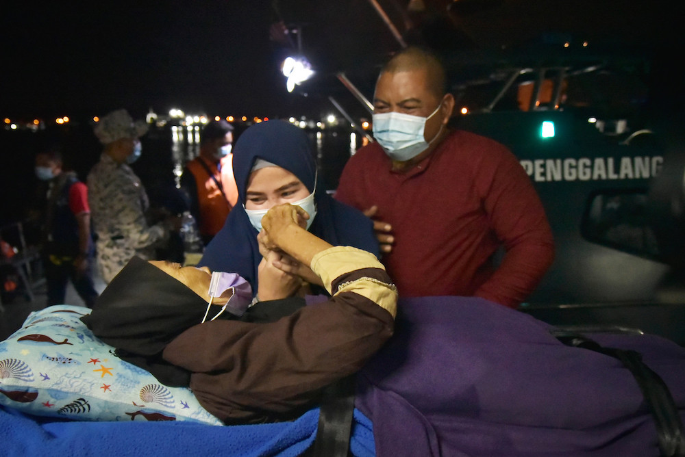 Salmah Adeh (left) finally meeting with her nephew Zamain Mau00e2u20acu2122in (right) and family at the Labuan International Ferry Terminal jetty, February 27, 2021. u00e2u20acu201d Bernama picnn