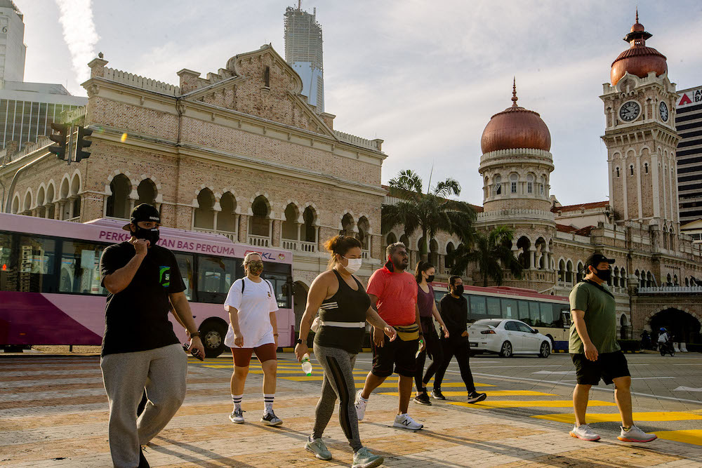 People wearing facemasks are near Dataran Merdeka in Kuala Lumpur February 21, 2021. u00e2u20acu201d Picture by Firdaus Latif