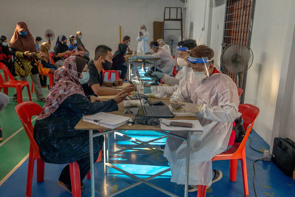Healthcare workers register members of the public for Covid-19 swab tests in Petaling Jaya February 28, 2021. u00e2u20acu201d Picture by Firdaus Latif