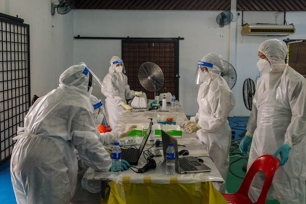 Healthcare workers are seen during a Covid-19 swab test in Petaling Jaya February 28, 2021. u00e2u20acu201d Picture by Firdaus Latif