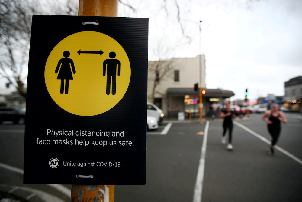People jog past a social distancing sign on the first day of New Zealandu00e2u20acu2122s new coronavirus disease safety measure that mandates wearing of a mask on public transport, in Auckland, New Zealand, August 31, 2020. u00e2u20acu201d Reuters pic