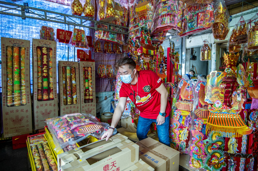 Religious goods store Feng Long Trading owner Sam Ying Meng arranges prayer items at his shop for the annual Bai Tian Gong festivities (Hokkien New Year eve) on the 9th day of the Lunar calendar (February 20). — Picture by Shafwan Zaidon