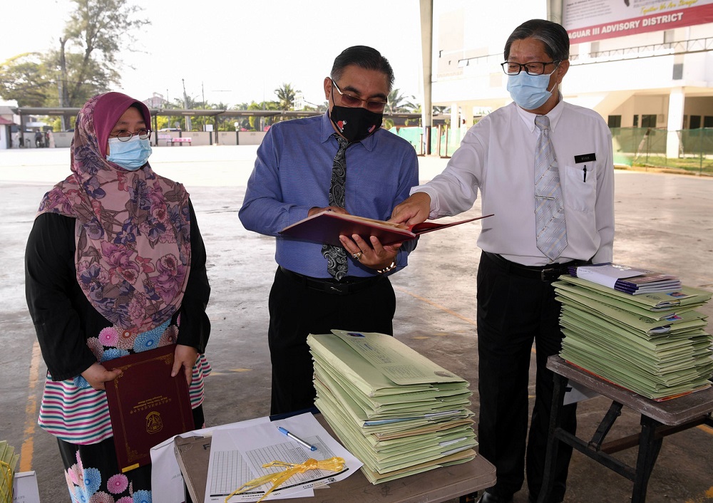 Deputy Education Minister 1 Muslimin Yahaya (centre) during a visit to Sekolah Menengah Jenis Kebangsaan Yoke Kuan on the first day of the Sijil Pelajaran Malaysia (SPM) examination in Sekinchan February 22, 2021. u00e2u20acu201d Bernama pic