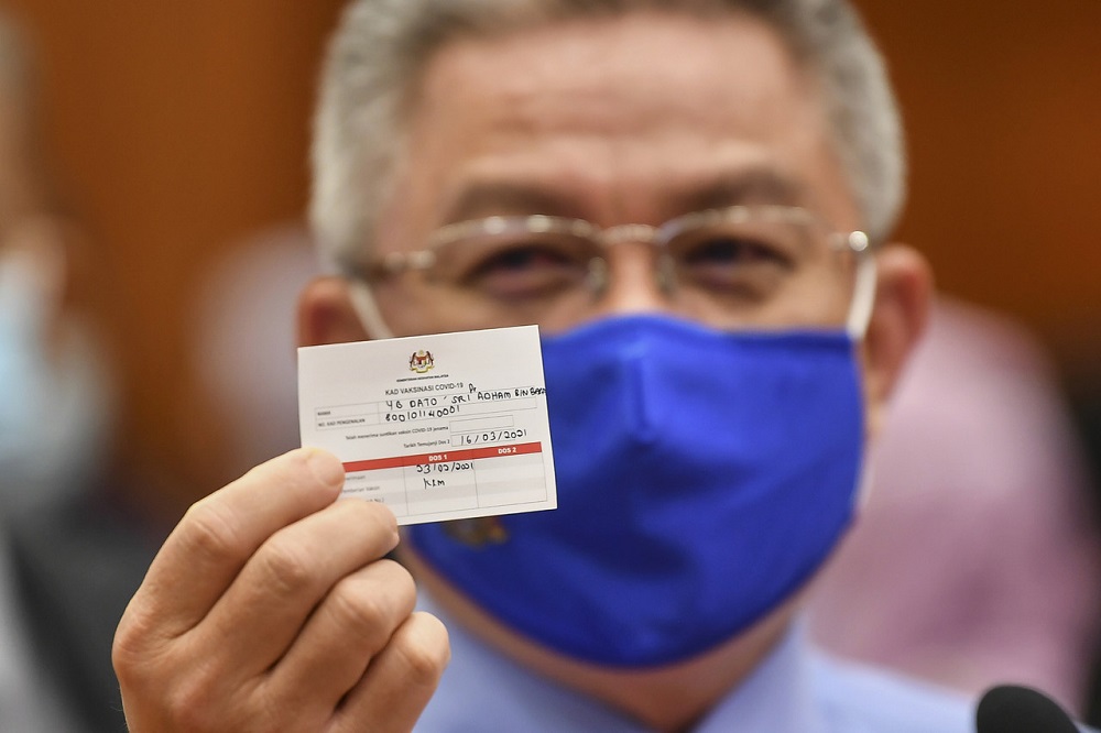 Health Minister Datuk Seri Dr Adham Baba with a sample of the vaccination card during a simulation exercise for the National Covid-19 Immunisation Programme, in Putrajaya February 23, 2021. u00e2u20acu201d Bernama pic