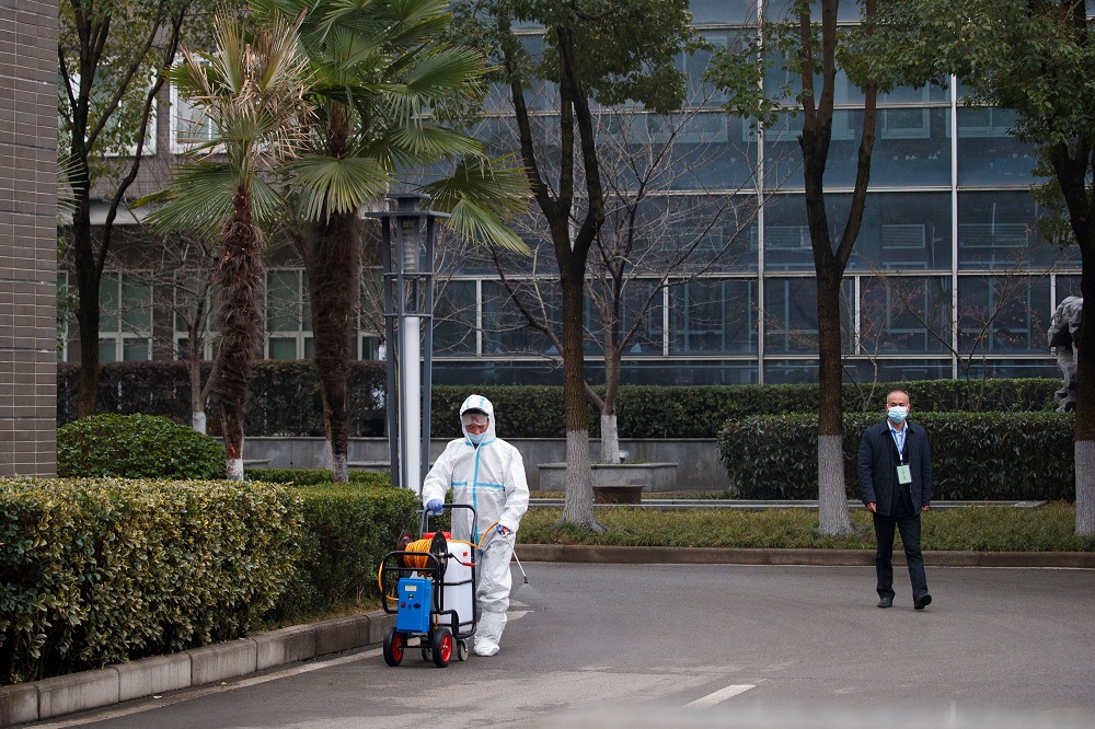 A worker in PPE disinfects the pavement after members of the World Health Organisation (WHO) team arrived at the Hubei Animal Epidemic Disease Prevention and Control Centre in Wuhan, Hubei province, China February 2, 2021. u00e2u20acu2022 Reuters pic