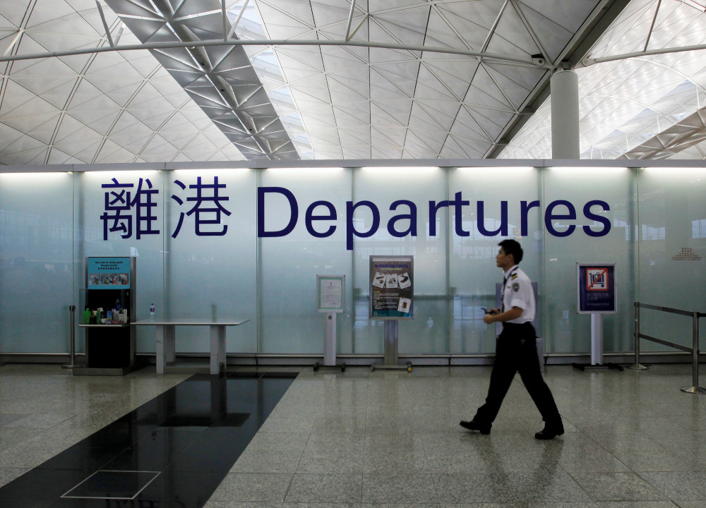 An airport security guard walks past a sign at the departure hall of Hong Kong Airport June 23, 2013. u00e2u20acu201d Reuters picnn