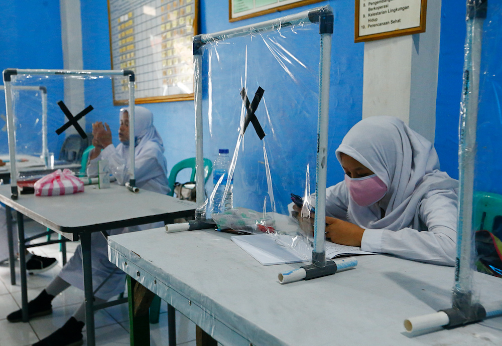 File photo of students wearing protective face masks check their mobile phones at the community hall offering free WiFi access provided by the government for online schooling in Jakarta, Indonesia, September 7, 2020. u00e2u20acu2022 Reuters picnnn