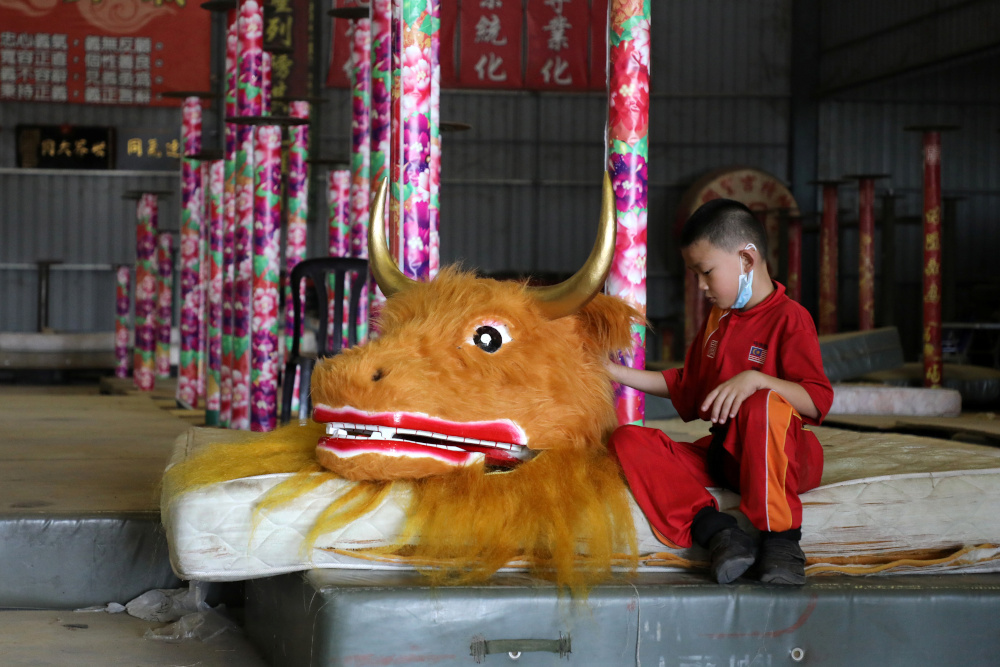 A member of the Kun Seng Keng Lion and Dragon Dance Association, touches an ox mask designed for Lunar New Year at a training centre, in Muar, Malaysia February 5, 2021. u00e2u20acu201d Reuters picnn