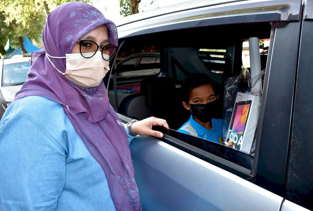 Deputy Minister of Entrepreneur and Cooperative Development Datuk Mas Ermieyati Samsudin (left) presents a tablet to a student at Masjid Tanah Community College, Alor Gajah, Feb 21, 2021. u00e2u20acu201d Bernama pic