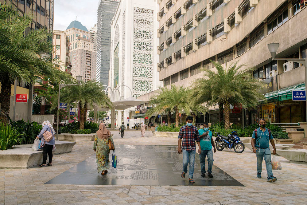 People wearing face masks walk on a street, during the implementation of the movement control order (MCO 2.0) in Kuala Lumpur February 2, 2021. u00e2u20acu201d Picture by Firdaus Latif
