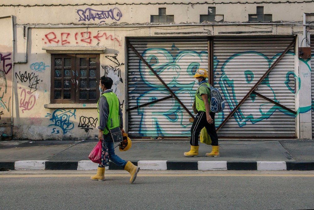 People wearing face masks walk on a street, during the implementation of the movement control order (MCO 2.0) in Kuala Lumpur February 2, 2021. u00e2u20acu201d Picture by Firdaus Latif