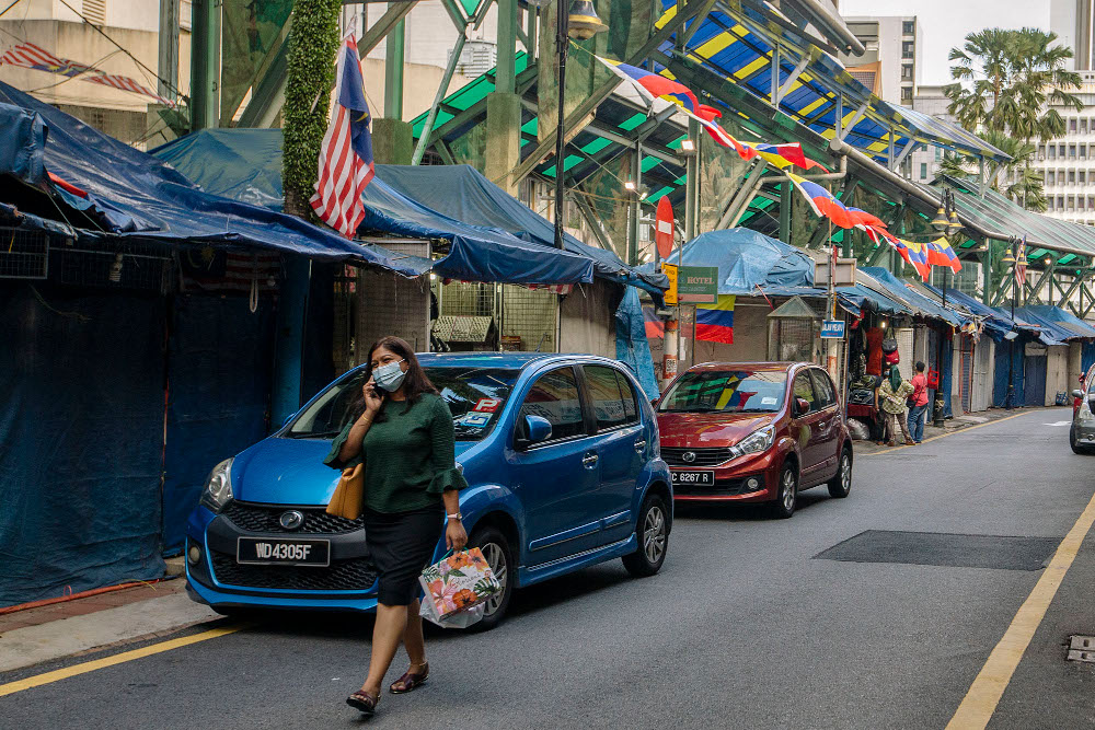 A woman wearing a face mask walks on a street, during the implementation of the movement control order (MCO 2.0) in Kuala Lumpur February 2, 2021. u00e2u20acu201d Picture by Firdaus Latif