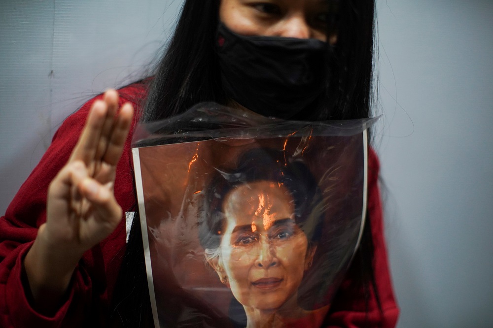 A demonstrator flashes a three-finger salute while holding a picture of Aung San Suu Kyi as Myanmar citizens living in Thailand protest against the military coup, outside Myanmar embassy in Bangkok, February 4, 2021. u00e2u20acu2022 Reuters pic