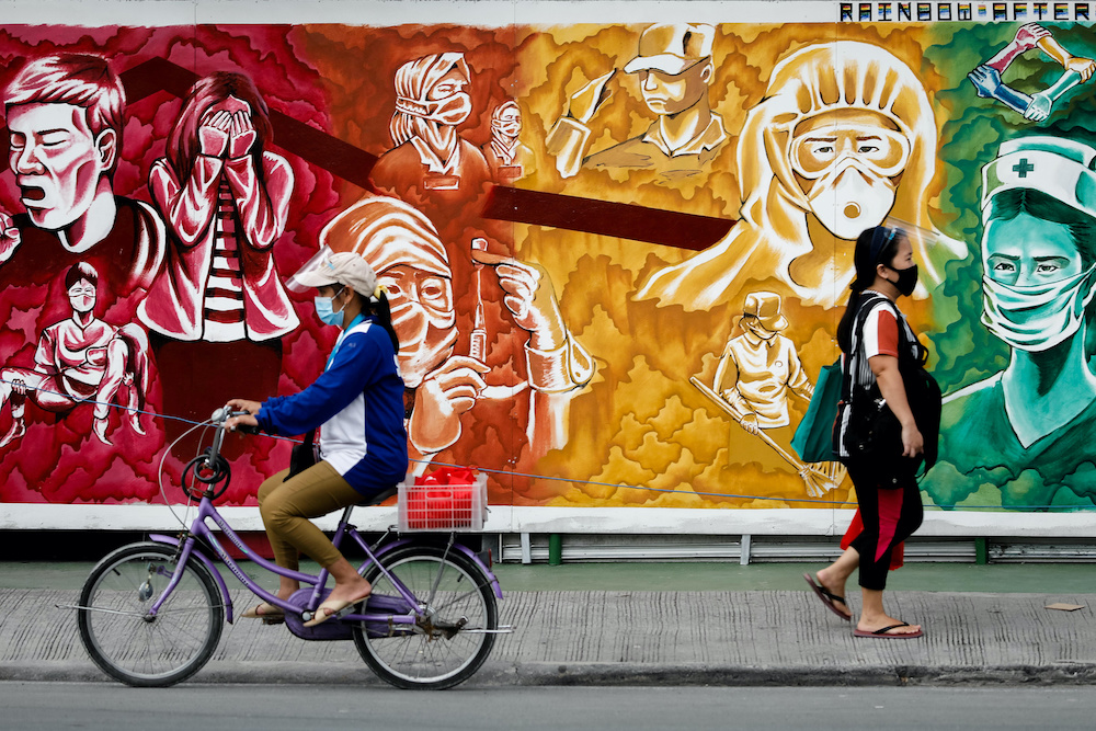 People wearing masks for protection against the coronavirus disease pass a mural dedicated to healthcare workers, in Pasig City, Metro Manila, Philippines, October 30, 2020. u00e2u20acu201d Reuters picnnnn