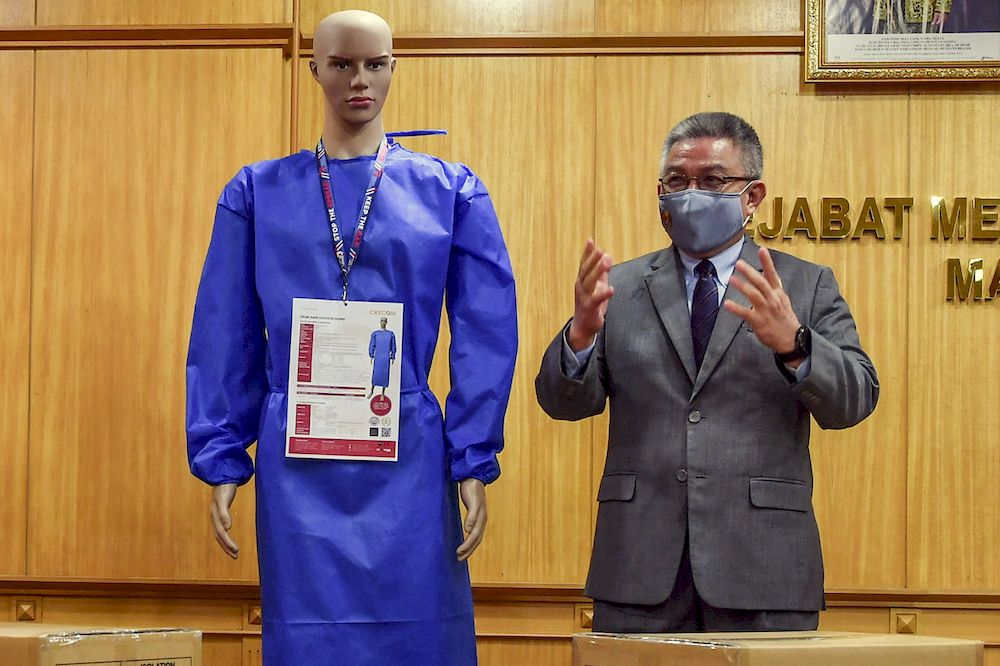 Health Minister Datuk Seri Dr Adham Baba posing with a mannequin displaying Personal Protective Equipment (PPE) during the handover ceremony of a million PPE pieces for the use of health frontline staff, Putrajaya, February 8, 2021. u00e2u20acu201d Bernama pic