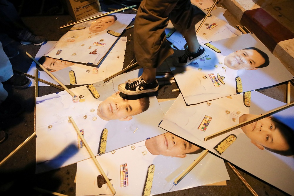 A person steps on prime minister and members of the government's photographs during a protest demanding the resignation of Thailand's Prayuth Chan-ocha in Bangkok February 19, 2021. u00e2u20acu2022 Reuters pic